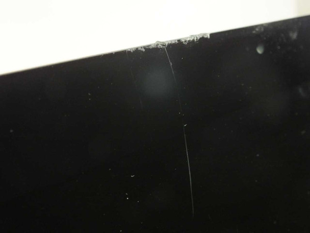 Close-up of iMac display glass top-right corner showing additional chips and flaking along glass edge