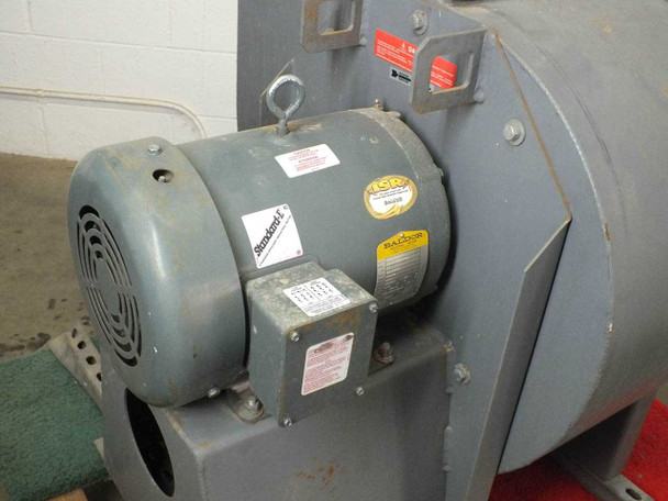 Close-up of Baldor 10HP industrial motor on Cincinnati Fan HDBI-150 showing Standard E efficiency label, yellow Baldor nameplate, red warning sticker, and junction box with typical industrial wear