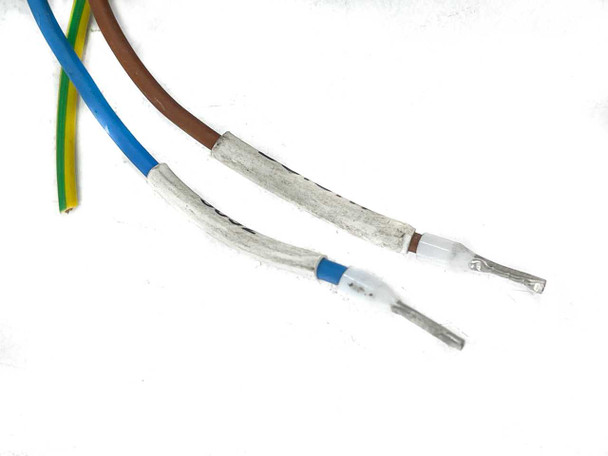 Close-up of wiring harness lead ends showing three conductors — blue, brown, and yellow/green ground — with bare ferrule terminations