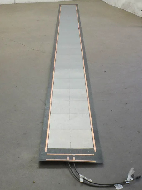 Uni-Solar PVL-136 flexible solar panel laid flat and fully unrolled showing full panel length with copper bus bars