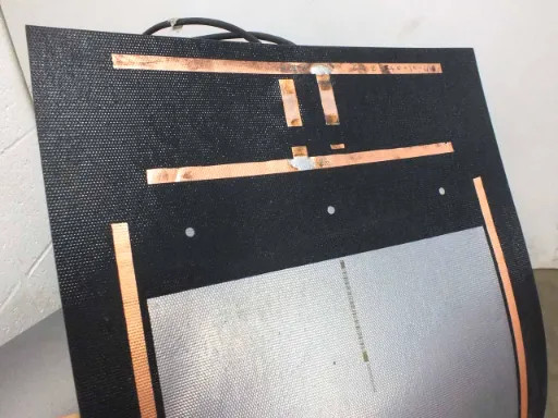 Uni-Solar PVL-136 panel back corner showing polymer substrate, copper bus bar strips, bypass diode tabs, and partial cell view