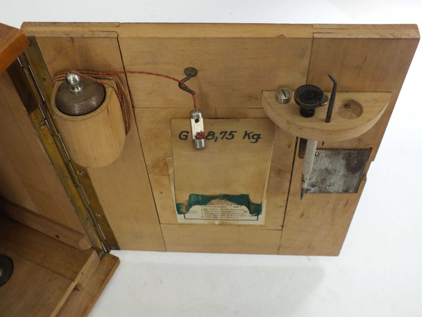 Inside of wooden case door showing accessory storage clips, thread container, and handwritten weight notation G 8.75 Kg