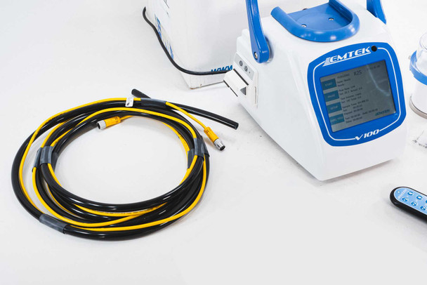 Close-up of EMTEK V100 sampler front panel touchscreen display and yellow-black RS2 sampling cable coiled beside unit