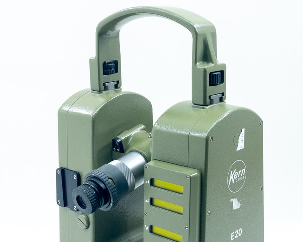 Kern E20 Theodolite top view showing carrying handle and telescope eyepiece with vertical/horizontal illuminated scale windows (yellow strips)