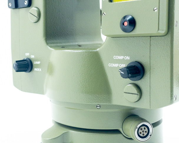 Kern E20 Theodolite side showing COMP ON / COMP OFF switch knob, power indicator LED, OFF/ON/LAMP/INDEX switch, and 6-pin power port at base