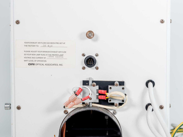 OAI 0130-041-04 – rear panel showing power lead connections (red and black terminals), multi-pin circular connector, exhaust vent opening, and OAI Optical Associates label