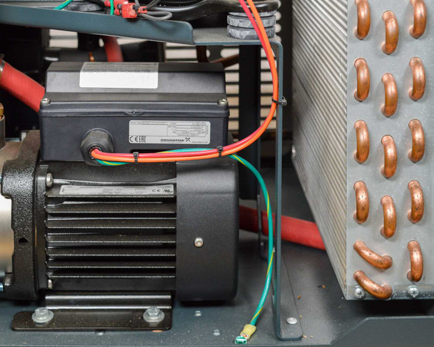 Haskris LX3-A2 – close-up of Grundfos circulation pump motor with CE marking, adjacent to copper tube heat exchanger coil, inside unit