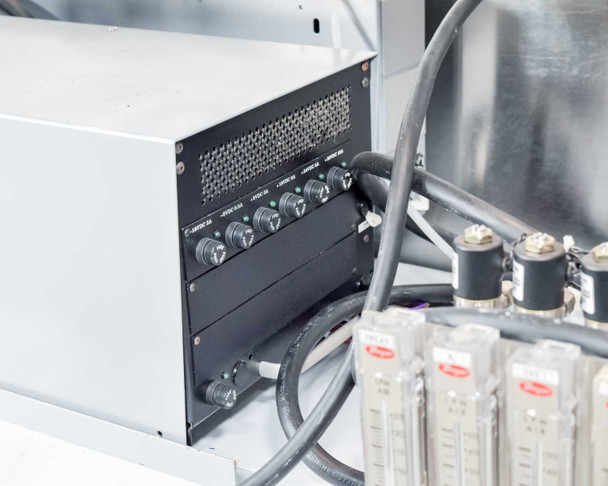 Close-up of internal controller sub-chassis with multiple rotary control knobs (labeled Load 1A, Load 2A, etc.) and adjacent Dwyer rotameter bank with solenoid valve heads