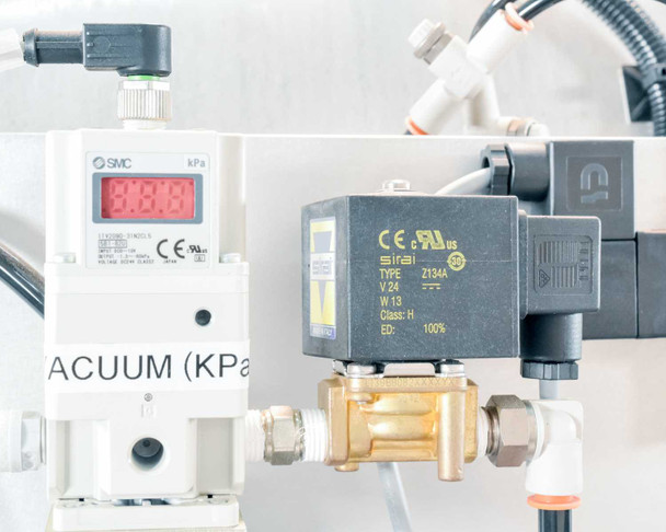 Close-up of SMC digital vacuum pressure transducer and Sirai Z134A 24VDC solenoid valve with CE and UL markings, vacuum (kPa) label visible