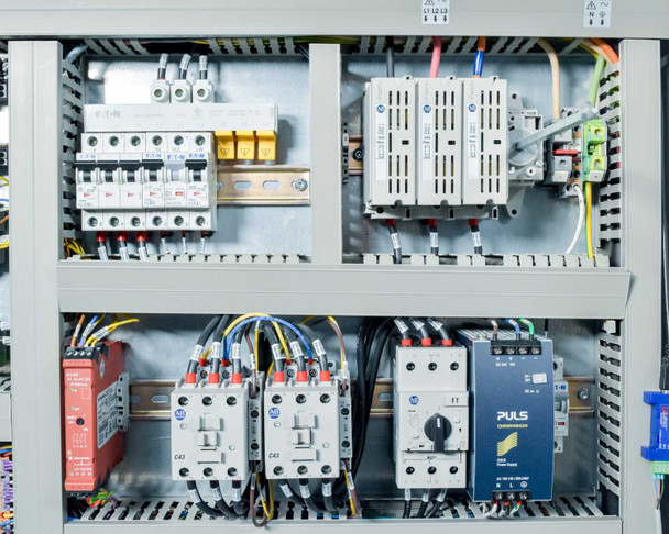 Electrical enclosure detail showing Eaton circuit breakers, three-phase contactors C42 and C43, and PULS DIN rail power supply