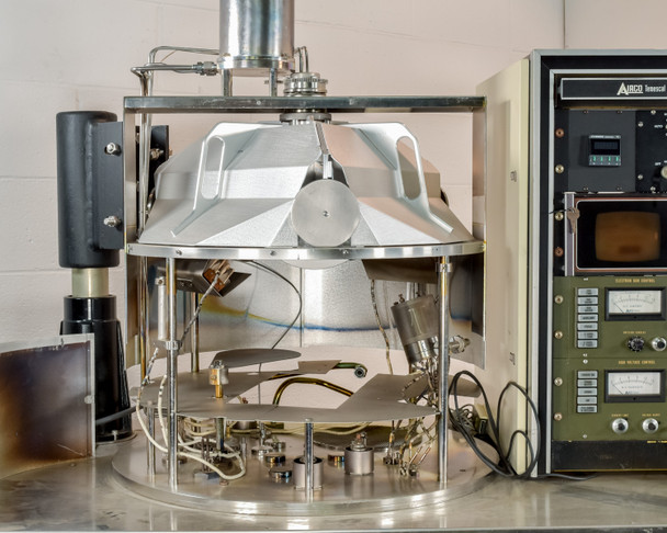 CHA Industries SEC-600 stainless steel bell jar chamber open on workstation — planetary substrate holder visible inside, Airco Temescal rack in background