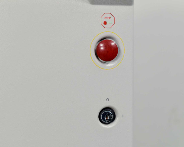 Lumenis Novus Varia front panel close-up showing red emergency stop button with STOP label and key switch in off position below
