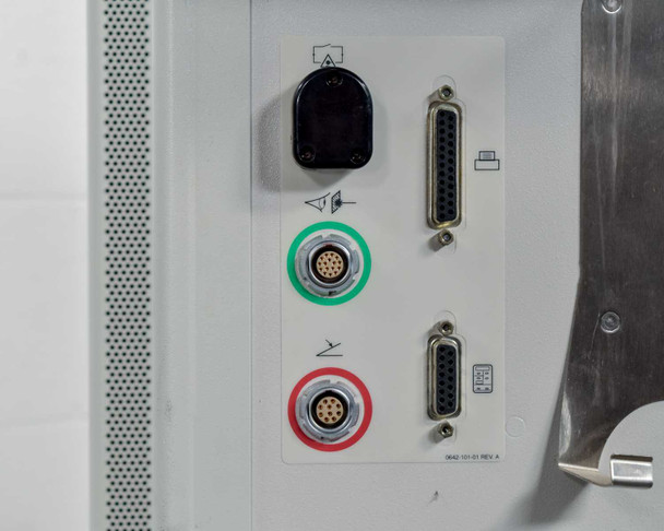 Lumenis Novus Varia side connection panel showing foot pedal connector, two DB25 parallel connectors, green-ringed and red-ringed multi-pin circular connectors, and panel label OKAD-101-01 REV A