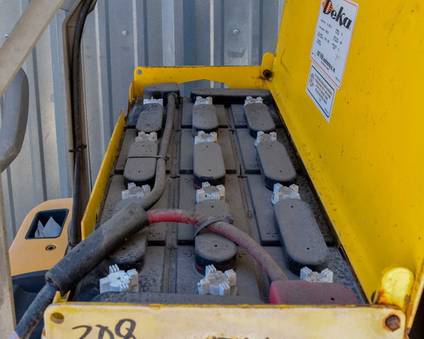 Deka 12-D85-9 24V battery – battery compartment open showing flooded lead-acid cells with corrosion deposits on terminals