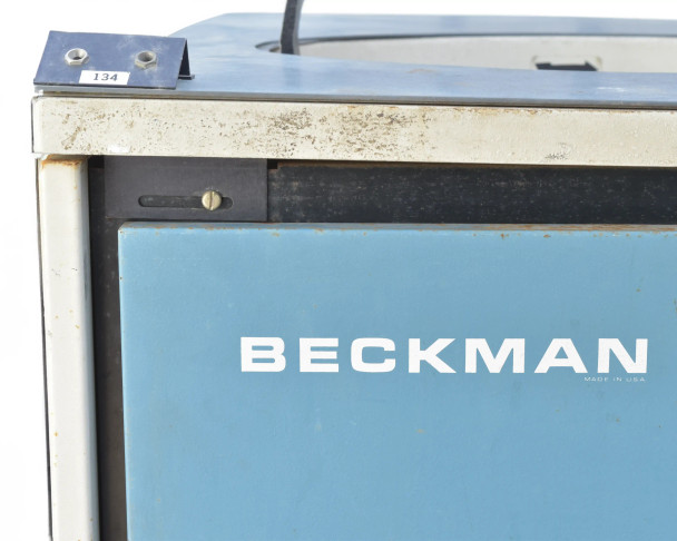 Beckman L5B-CT upper cabinet detail showing corrosion and surface rust along top frame rail and hinge area, Beckman logo on blue panel