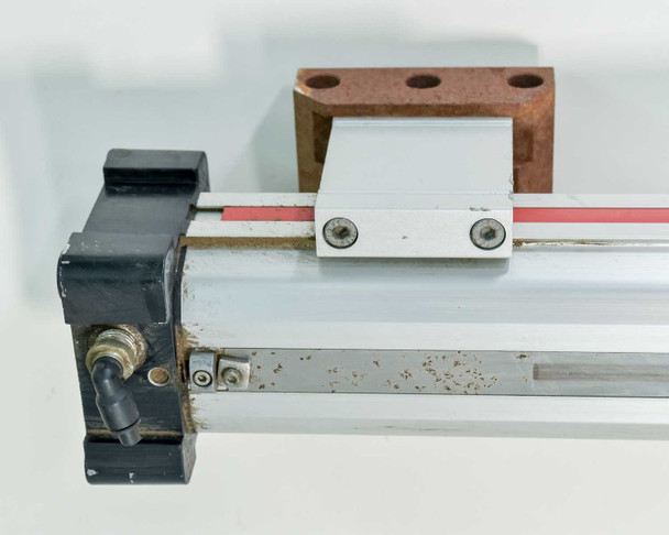 Parker OSP-P50 end detail showing pneumatic inlet port fitting, carriage assembly, and mounting hardware