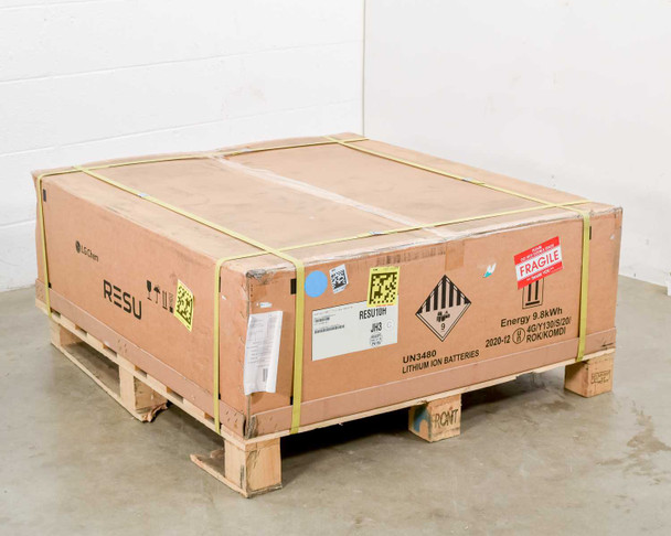 LG Chem RESU10H lithium-ion solar battery in original cardboard shipping box on wooden pallet, strapped with yellow bands — full view showing UN3480 hazmat label and Fragile sticker