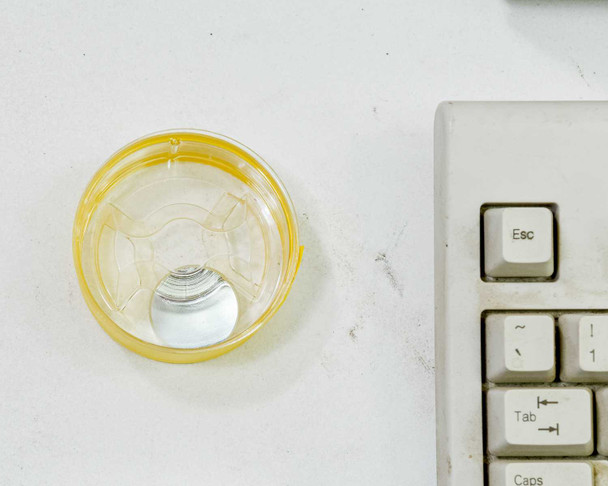 Close-up of yellow plastic lens/mirror holder accessory from Labsphere RSA-HP-8453 system, next to keyboard