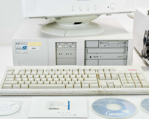 HP Vectra XM 5/120 Series 4 desktop computer with Compaq KB-3923 keyboard, two Labsphere CDs, and accessories on table; cracked casing visible on computer side panel