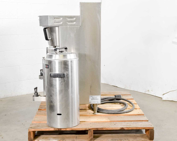 Fetco CBS-61H coffee brewer side profile on pallet with one Luxus dispenser and power/water hose visible