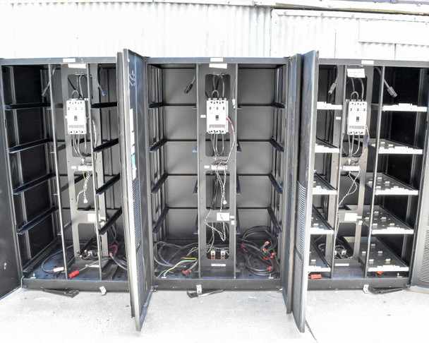 Three Eaton 9395 battery cabinets with doors open showing empty battery trays, interior wiring, and HKD-DC breakers
