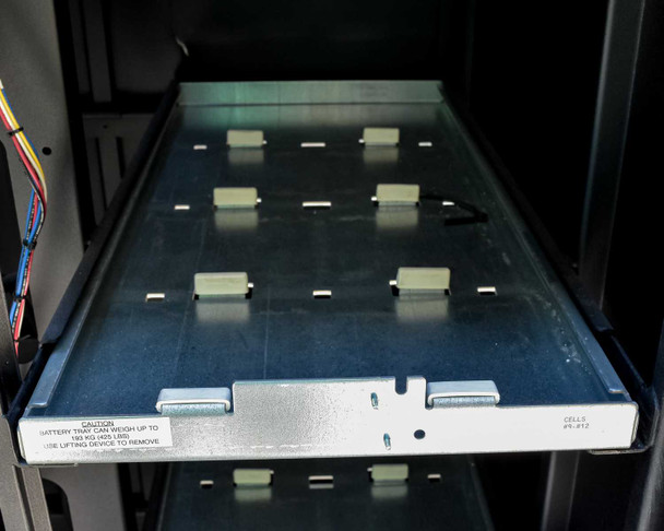 Empty battery tray extended from cabinet showing battery cell mounting clips and slide rails – tray label visible