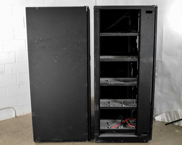 Eaton 9390 battery cabinets separated — left cabinet open showing empty battery tray shelves, right cabinet side panel view
