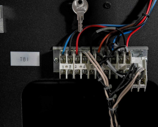 TB1 terminal block inside Eaton 9390 battery cabinet with interconnect wiring and cabinet key
