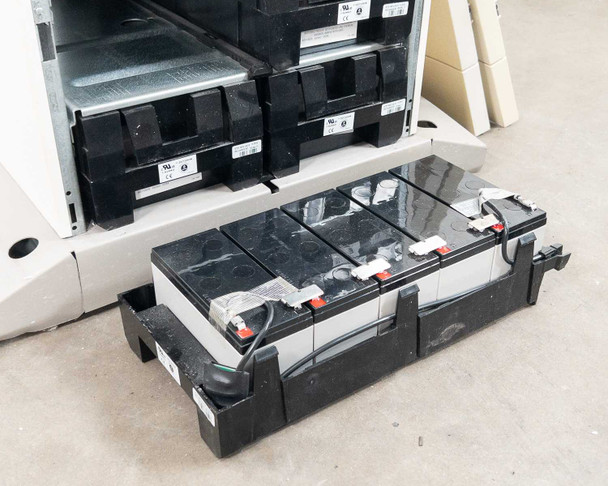 Best Power Axxium Pro battery module removed and sitting on floor, showing three sealed lead-acid cells with red and black terminal connections