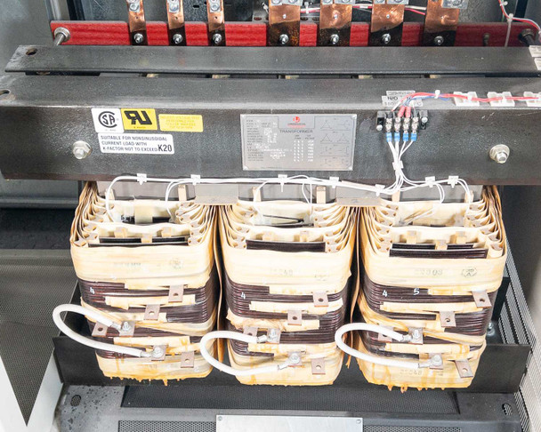 PDI Power Pak M-4 — lower interior close-up of three-phase transformer cores with UL and CSA certification labels and copper bus bar connections at top