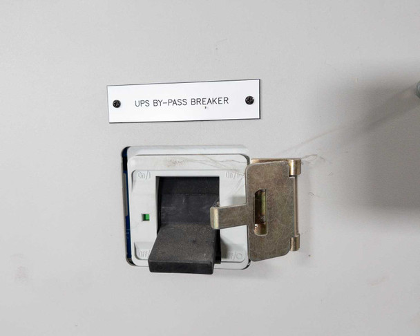 Transfer switch front panel close-up showing UPS By-Pass Breaker toggle switch with locking hasp