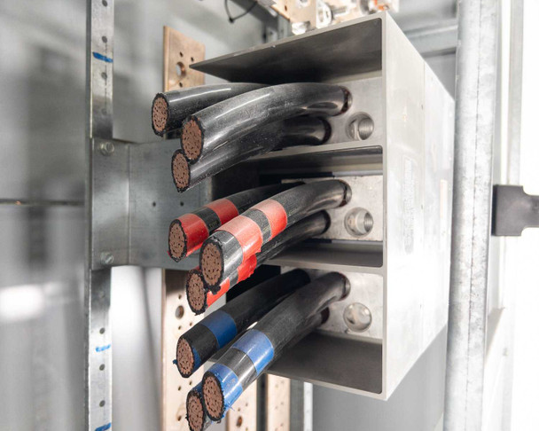Siemens switchboard incoming cable compartment – multiple large conductors with red and blue phase tape markings entering lug termination block