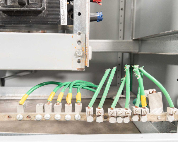 Siemens switchboard ground bar – interior detail showing green and yellow ground/neutral conductors terminated at ground bus bar