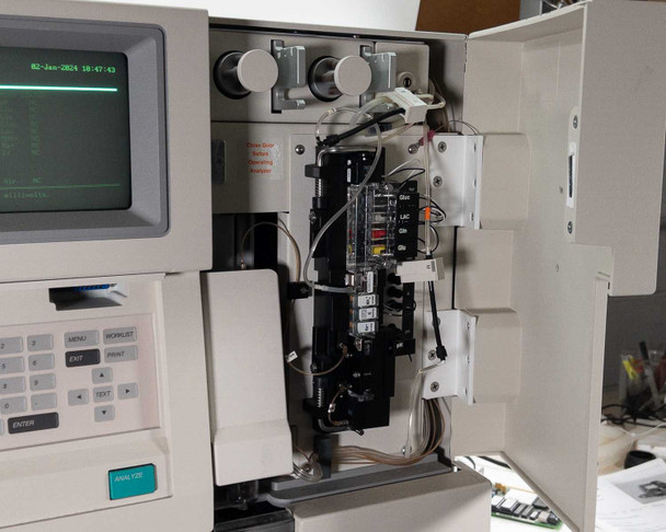 Nova Biomedical BioProfile 100 Plus – front door open during power-on showing CRT screen with 02-Jan-2024 timestamp, sensor module array, and internal cabling