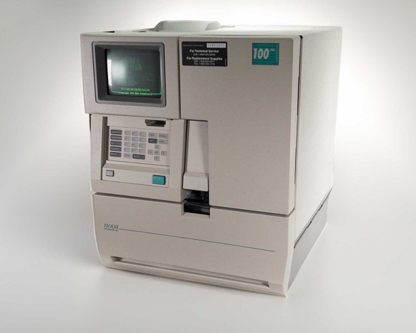 Nova Biomedical BioProfile 100 Plus analyzer – three-quarter front-left view showing CRT display, keypad, printer, and sample access door