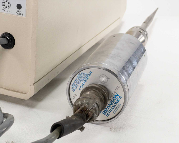 Branson Ultrasonics converter close-up – piezoelectric transducer head with multi-pin RF cable connector attached and Branson Ultrasonics label visible