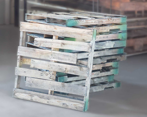 Stack of 48x48 oversized wooden pallets showing weathered and painted surfaces, stacked vertically in warehouse