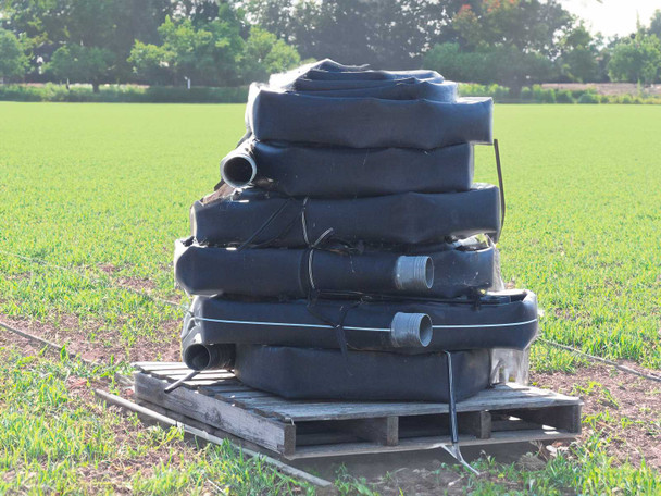 Toro Blueline 4-inch oval drip irrigation hose lot on wooden pallet with visible emitter fittings and tie straps