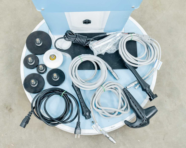 Lumenis NuEra Tight top storage tray open showing handsets, RF heads, grounding pad, cables, and power cord