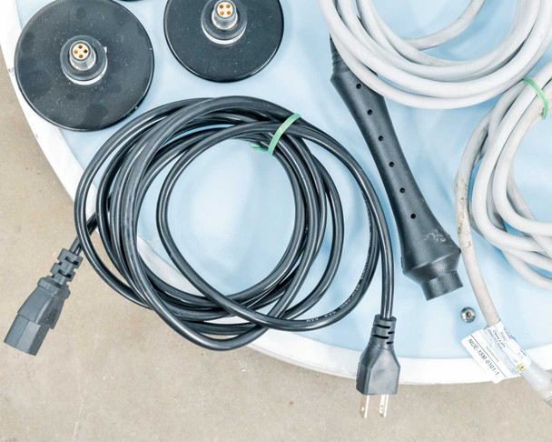 Lumenis NuEra Tight accessories showing power cord and face handset handle with cables on blue storage tray