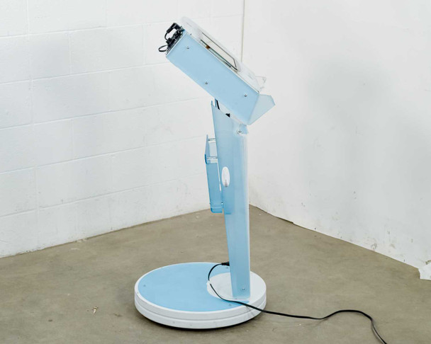 Lumenis NuEra Tight right side profile view showing console arm angle, storage tray opening, and round wheeled base