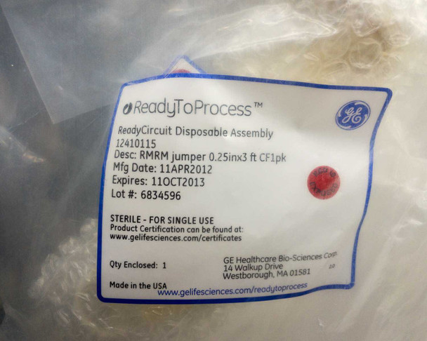 GE ReadyToProcess 12410115 label close-up showing RMRM jumper description, Mfg date 11APR2012, expiration 11OCT2013, lot number, sterile for single use, and Made in USA