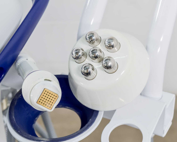 Close-up of Pollogen Legend+ SMD Applicator VO with gold matrix tip insert and round multi-electrode applicator head resting in holder