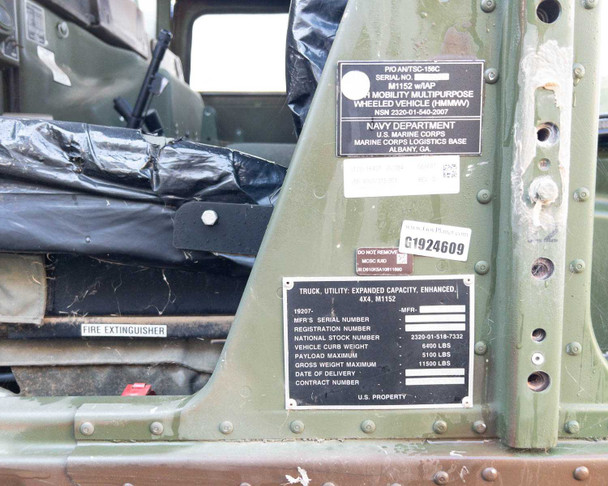 AM General M1152 HMMWV door jamb area showing data plate, MCSC IUID tag, and Navy Department Marine Corps Logistics Base markings