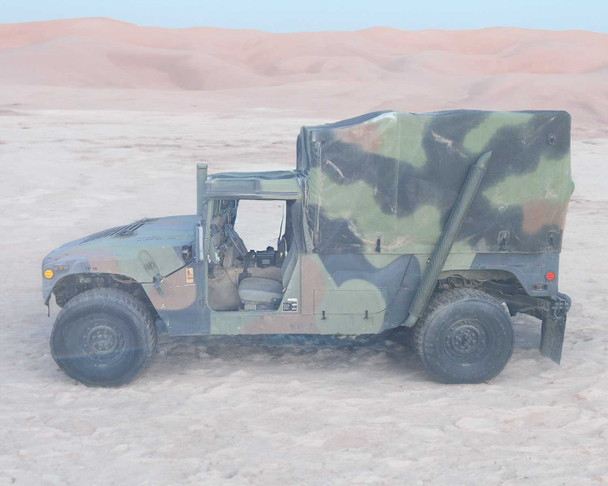 AM General M1152 HMMWV full left-side profile view in desert environment showing soft top and overall condition
