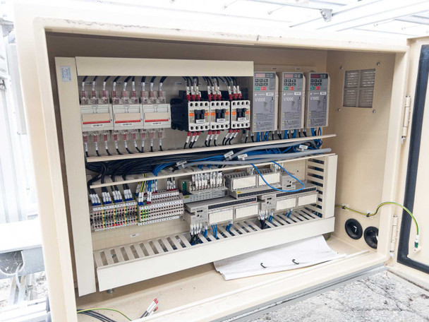 Conveyor control panel interior – full view showing Yaskawa V1000 inverter drives, contactors, terminal blocks, and wiring