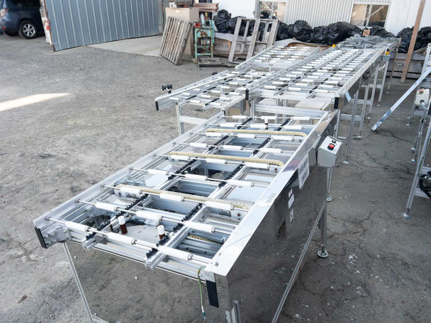 Two Excel Flow SC23460 long conveyor sections positioned outdoors – aluminum frame, cross-member roller supports, and cabling visible