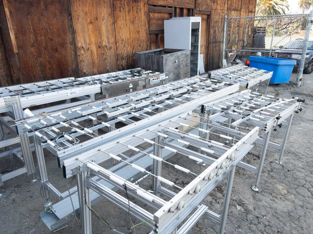 Excel Flow SC23460 conveyor sections spread out on outdoor ground – wide overview showing all six units with aluminum extrusion frames