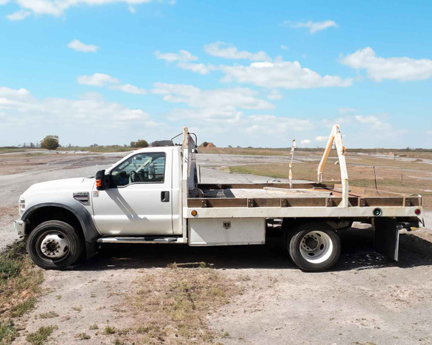 2009 Ford F450 XL Super Duty – driver-side profile view showing full Scelzi 8x12 flatbed with low wood stakes