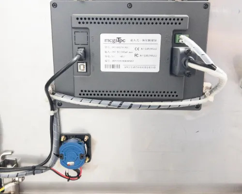 Rear of Mcgs TPC touchscreen HMI panel removed from Lneya SUNDI-255 showing wiring connections, CE/FCC markings, and mounting hardware